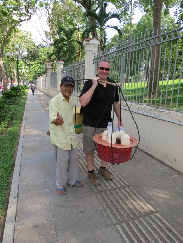 Coconut vendors are everywhere in the streets of Saigon.  On a hot day, a fresh coconut with a brightly colored bendy straw is always a welcoming treat (especially for kids).  The vendors use a lot of trickery to sell their product, so tourists need to be careful.  This vender's modus operandi was encouraging tourists to feel how heavy his apparatus is.  Before we knew it, he had pulled out his machete and, at lightning speed, had the coconuts in the girls' hands. 
