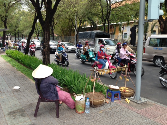 A street vendor taking a nap in the hot Saigon sun. 