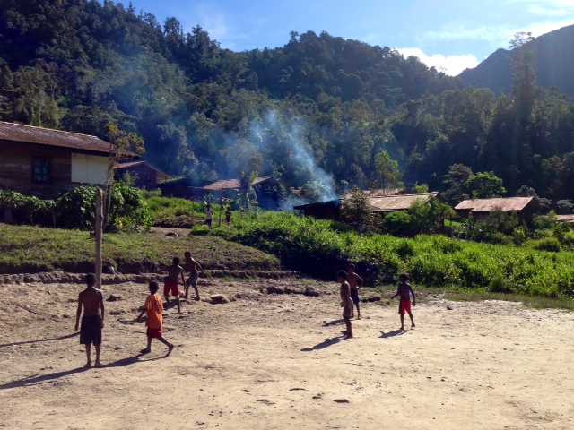 Kids playing on a dirt court.
