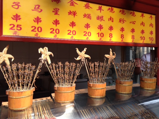 These are live scorpions on a stick.  I have a video of this scene that I will post when we go off site (the internet connection is too slow to do it here).  As soon as the girls saw them, they had to try them!  They are grilled and salted.  In all honesty, they are pretty good!   