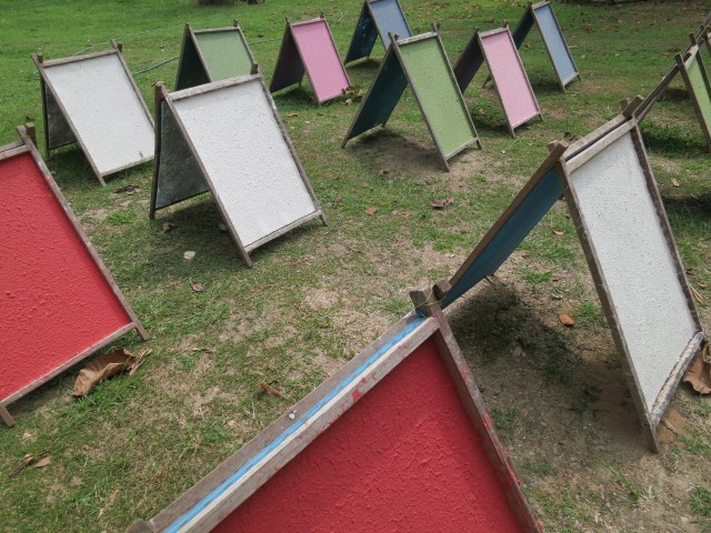 Poo poo paper drying in the sun.  After several hours, the paper is pulled off the screen and stacked. 