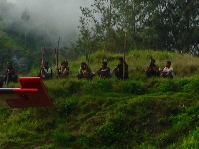 This group of men, from a neighboring village, watched the plane arrive, but kept their distance. They were dressed in tribal paint, wore headdresses, and carried bows, arrows, and spears. I was hoping to get a better picture of them, but they ran off before I could. Narelle took this picture before they ran off.
